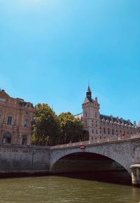 Arch bridge over river against buildings