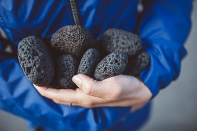 Midsection of person holding stones