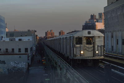 Train in city against sky at dusk