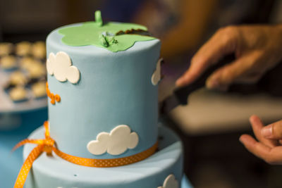 Men hands cutting with knife piece of birthday cake