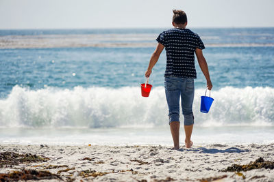 Rear view of man standing on beach