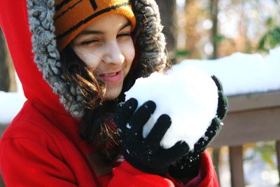 Portrait of smiling young woman standing in snow