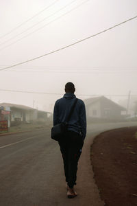 Rear view of man walking on road