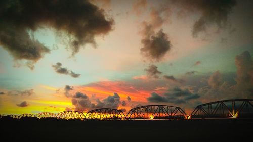 Silhouette of bridge against dramatic sky