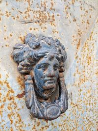 Close-up of old statue against wall