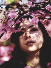 Close-up portrait of woman with pink flowers