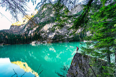 Hiker standing on rock by lake