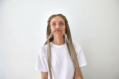 Portrait of beautiful young woman against white background