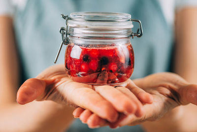 Fruit fermentation. woman holding jar with fermented fruit.