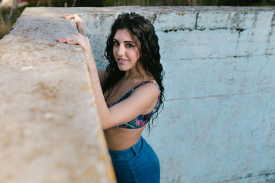 Portrait of beautiful woman standing at abandoned swimming pool