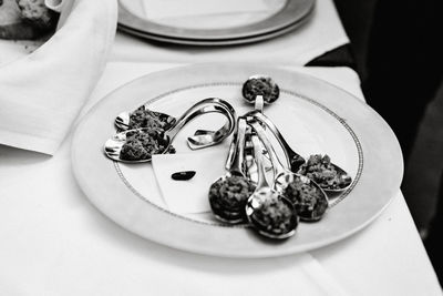 High angle view of spoons with food in plate on table