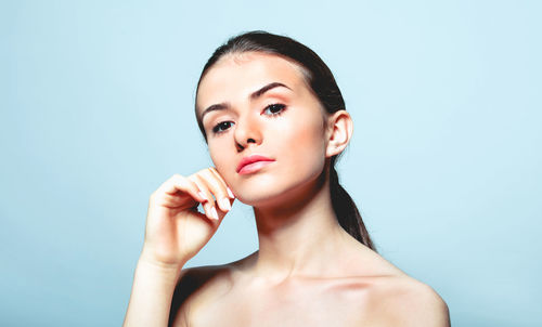 Portrait of young woman against gray background