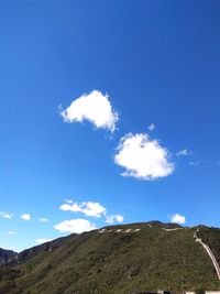 Low angle view of mountain against blue sky