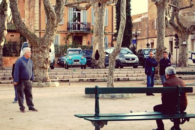 Rear view of people walking on street in city