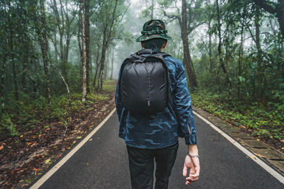 Rear view of man walking in forest