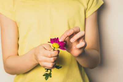 Midsection of woman holding flower