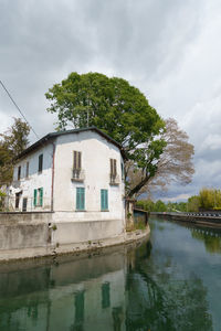 Buildings by lake against sky