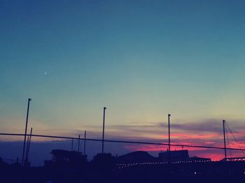 Silhouette street against sky at sunset
