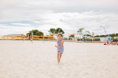 Diverse mixed race pre school age girl at sandy beach on a summer day 