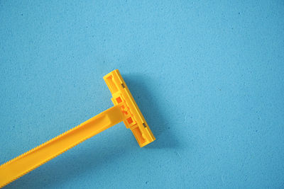 High angle view of yellow sign on blue wall