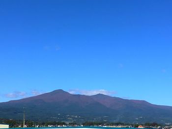 Scenic view of mountains against blue sky