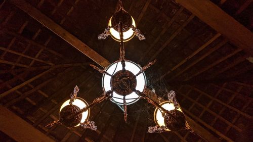 Low angle view of illuminated chandelier hanging in building