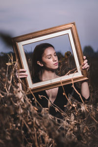 Close-up of young woman against sky