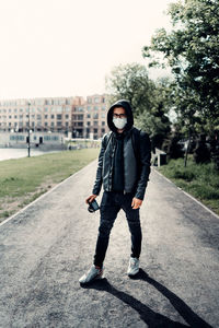 Full length portrait of man standing on road