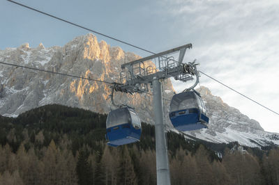 Low angle view of overhead cable car against rocky mountain