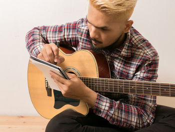 Midsection of man playing guitar