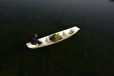 Man fishing in boat on lake