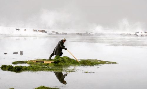 Man surfing in sea against sky