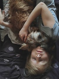Portrait of young woman lying on bed at home