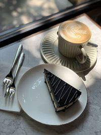 High angle view of coffee cup and cake on table