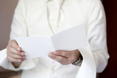 Midsection of man holding paper