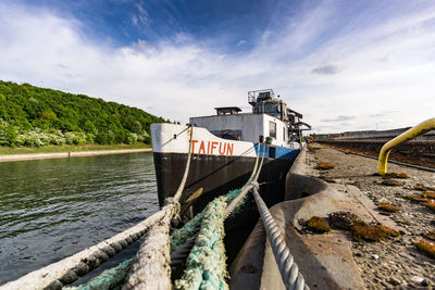 Fishing boat moored on sea against sky