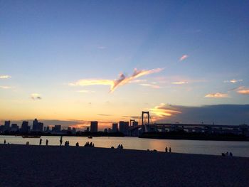 Scenic view of beach against sky at sunset