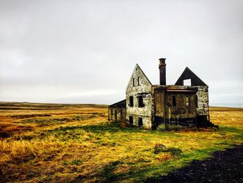 Abandoned built structure on field against sky