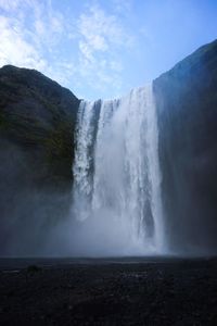 Scenic view of waterfall against sky