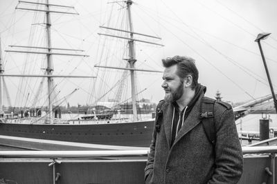 Mature man standing against sailboat