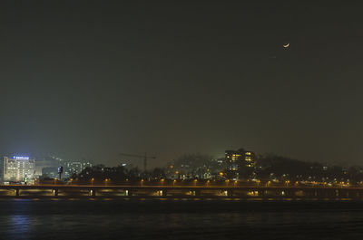 Illuminated city against sky at night