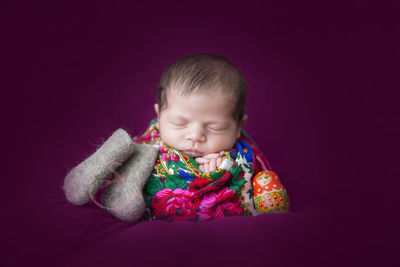 Portrait of cute baby boy against gray background