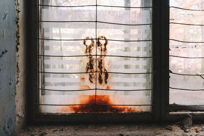 Close-up of old broken rusty window with painting