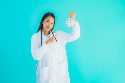 Young woman standing against blue background