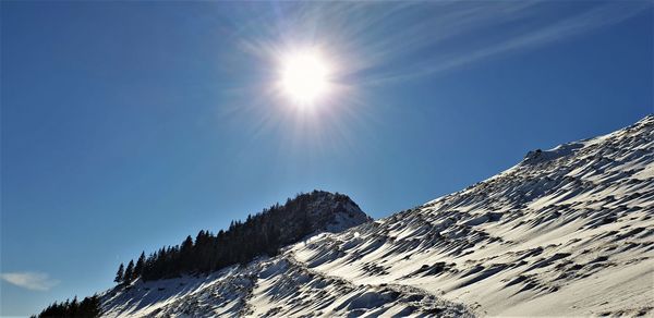 Low angle view of snowcapped mountains against sky