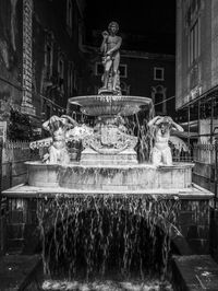Statue fountain against building
