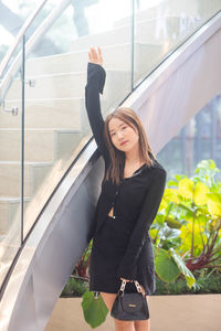 Portrait of young woman standing in city