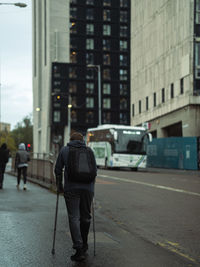 Rear view of man walking on street in city