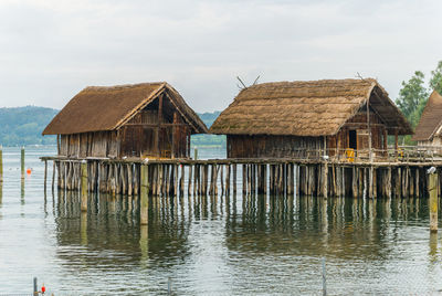 Wooden house by building against sky