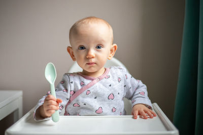 Portrait of cute baby girl with arms raised